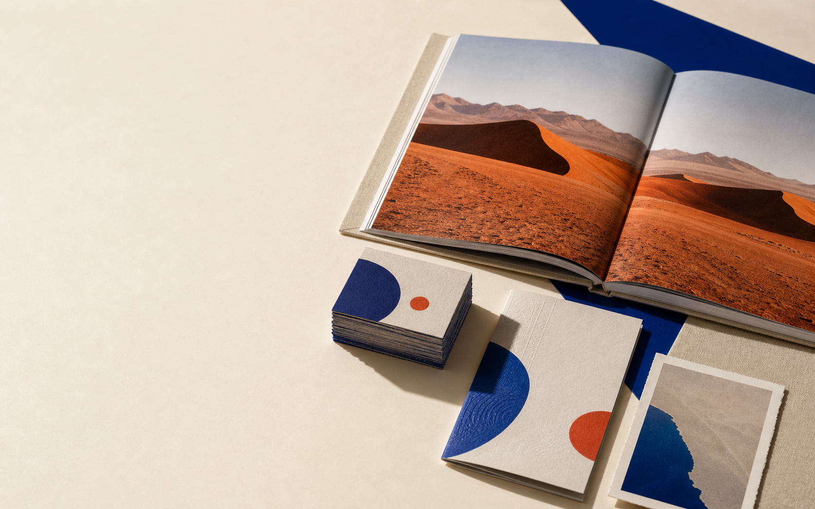 A premium photobook, business cards and printed stationery arranged on a studio surface